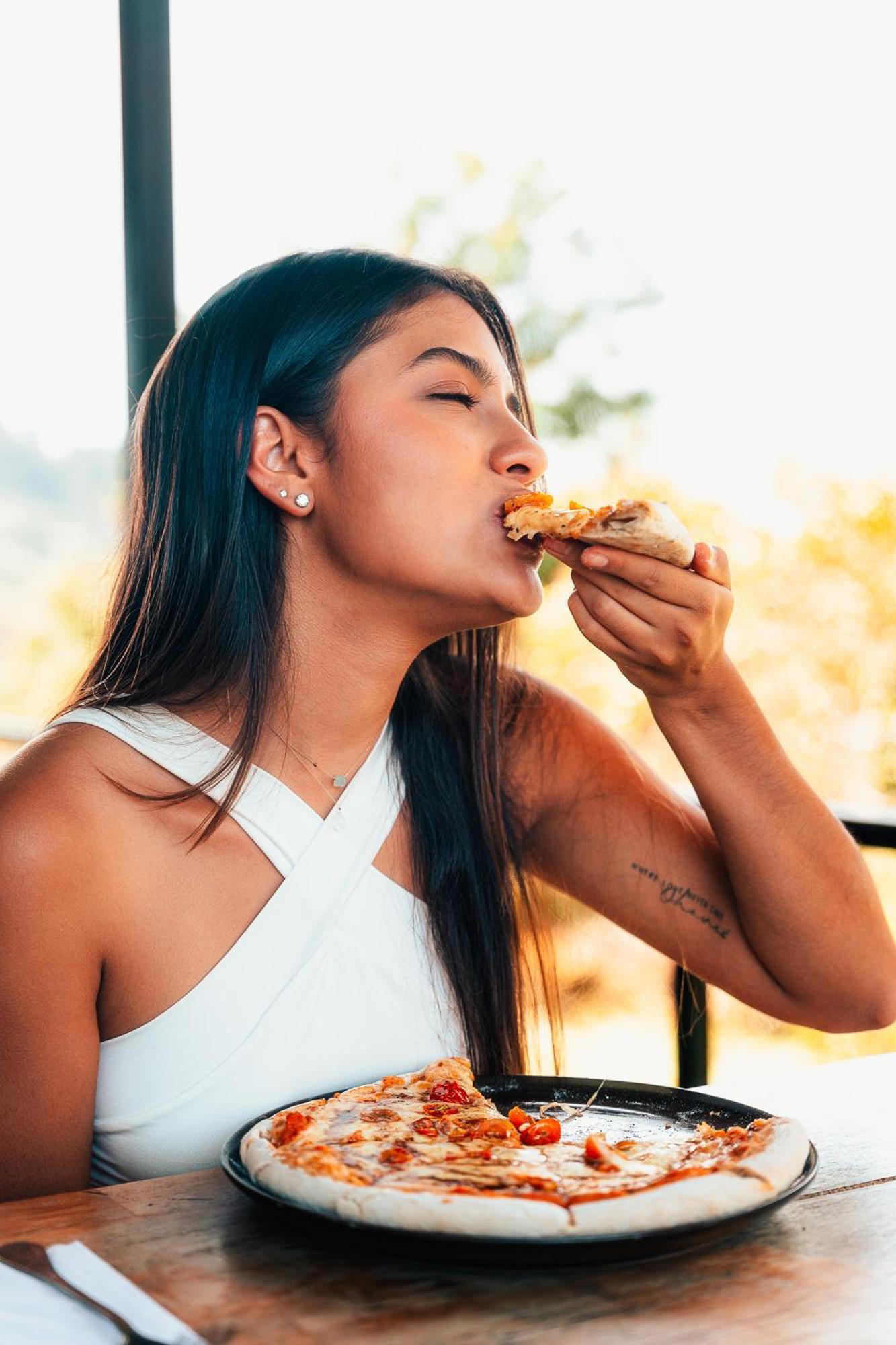 The Boato Hotel Guatapé Εξωτερικό φωτογραφία A woman eating pizza